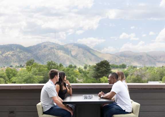 Three people sitting at a table playing a board game.