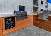 Thumbnail 17 of 22 - bbq area with two grills in front of an apartment building