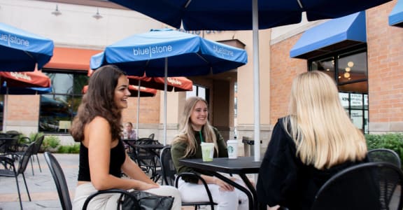 three women sitting at a table under an umbrella at Bluestone Lofts, Duluth, Minnesota