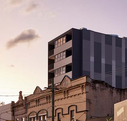 a city street at dusk with a tall building