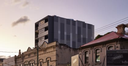 a city street at dusk with a tall building