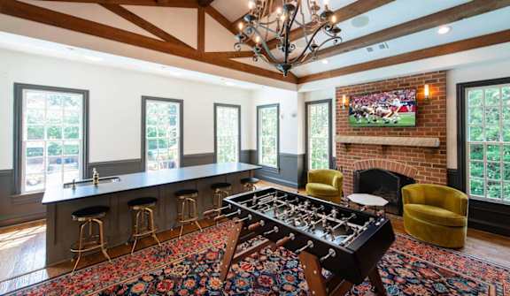 A large room with a blue couch and a chandelier. at Fairfax Square Apartments, Fairfax, VA, 22031