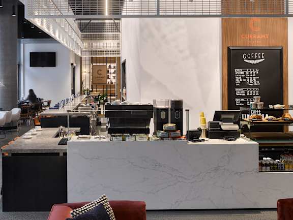 A modern cafe with a marble counter and a blackboard menu.
