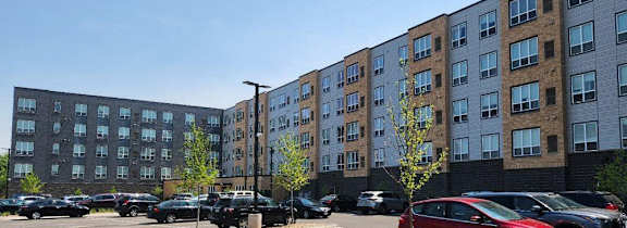 a parking lot with cars in front of a large building