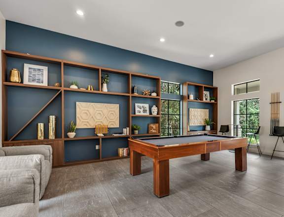 A room with a pool table and a couch.