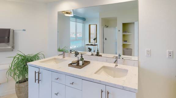 A bathroom with a double sink vanity and a large mirror. at Esprit Apartments, Marina del Rey, CA, 90292