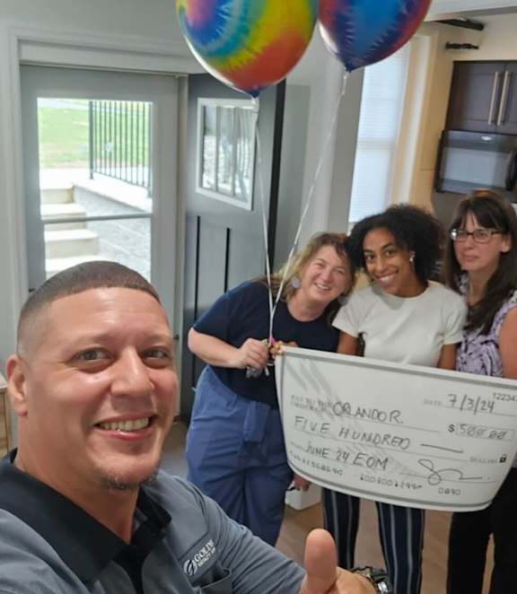 A group of people are holding a check for $582.