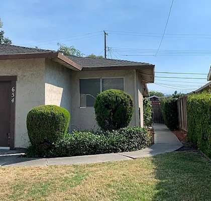 652-654 Chemeketa Drive, San Jose, CA 95123 A house with a brown garage door and a green hedge.