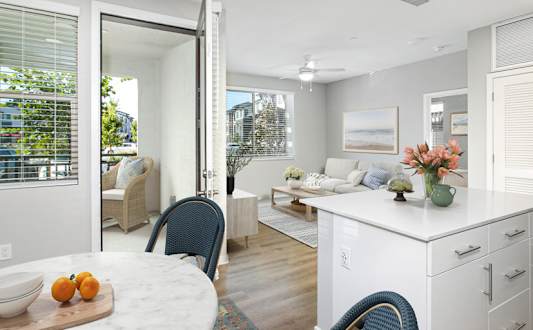 A kitchen with a table and chairs in front of a window.