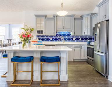 a kitchen with stainless steel appliances and a large island with blue tiles
