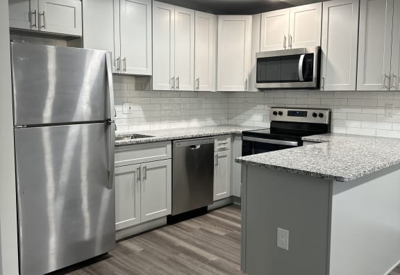 a kitchen with white cabinets and stainless steel appliances