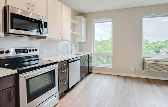 Kitchen with upper and lower cabinets against one wall with stainless steel appliances