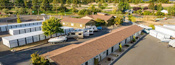 A large building with a brown roof is surrounded by a parking lot.