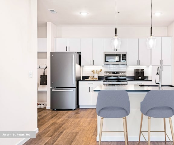 A kitchen with a refrigerator, stove, and bar stools.