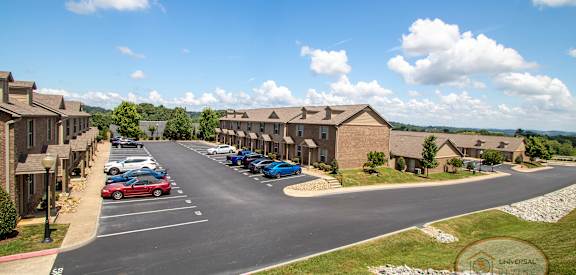 A parking lot with cars and apartment buildings in the background.