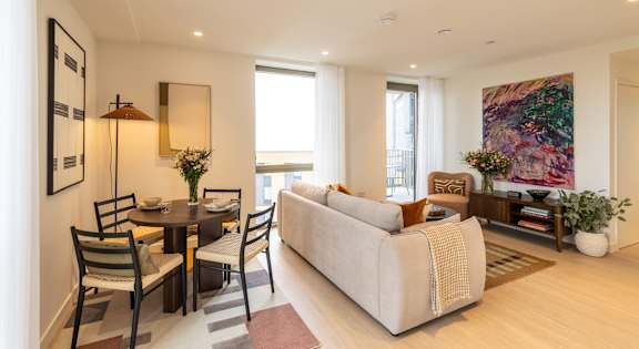 A living room with a couch, chairs, and a dining table.