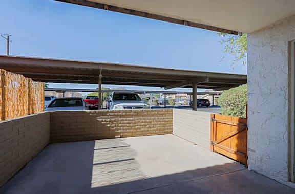 A parking lot is visible through a covered walkway.