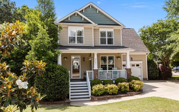 the front of a house with a porch and stairs