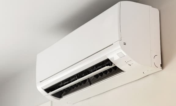 A white air conditioner unit mounted on a wall.