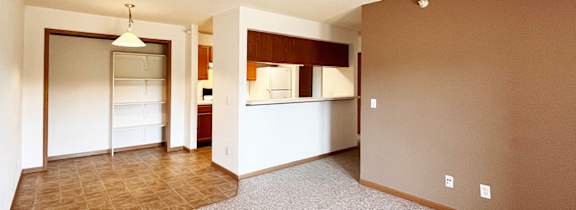 A room with a carpeted floor and a brown wall.