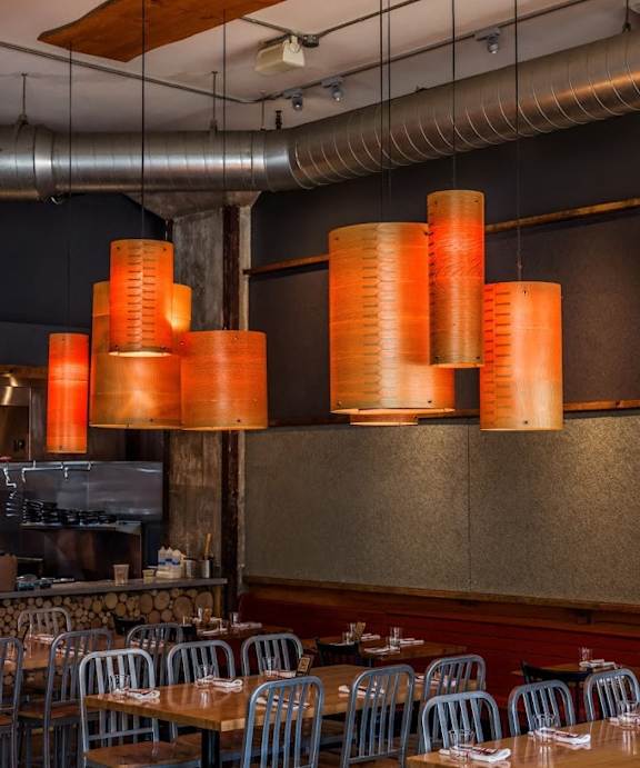 the interior of a restaurant with tables and chairs and orange lights