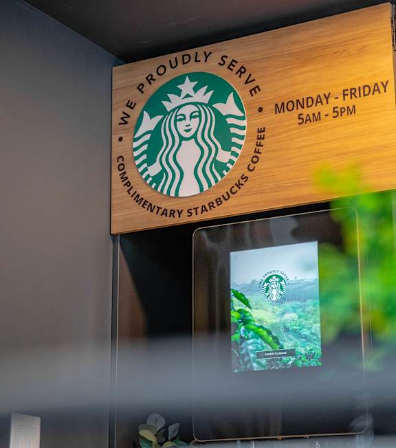 A Starbucks sign is hanging on the wall.at Vibe Apartments at Arbour Lake, Calgary