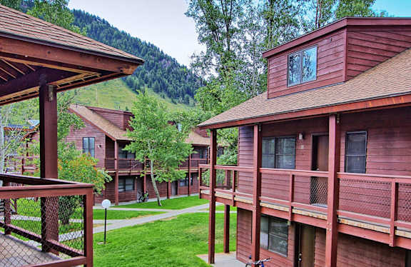A mountain is behind a building with red siding.