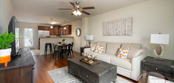 A living room with a white couch and a wooden coffee table.