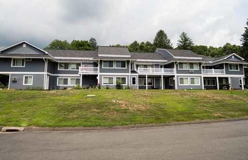 a large apartment building on a grassy hill