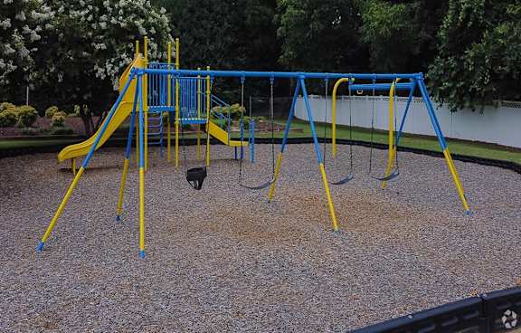 a swing set at a playground in a park at Colony Townhomes, Raleigh, 27609