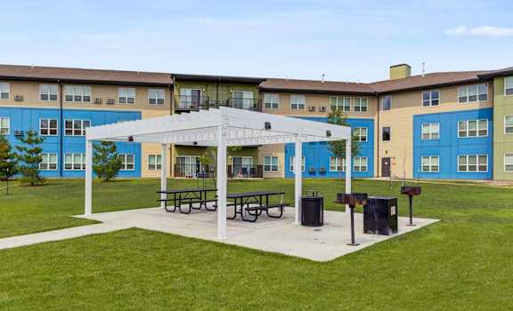 a picnic area in front of an apartment building