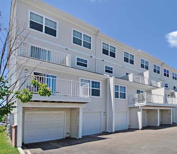 a street view of an apartment building with a car parked in front