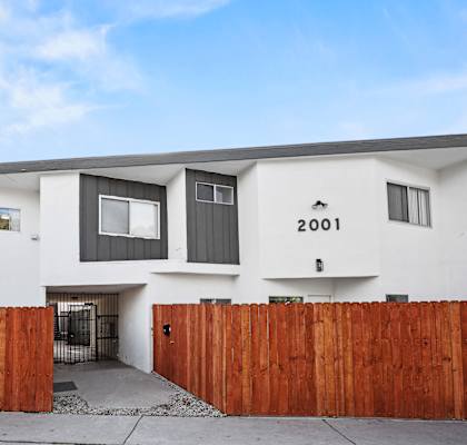 A modern house with a white facade and a black door.