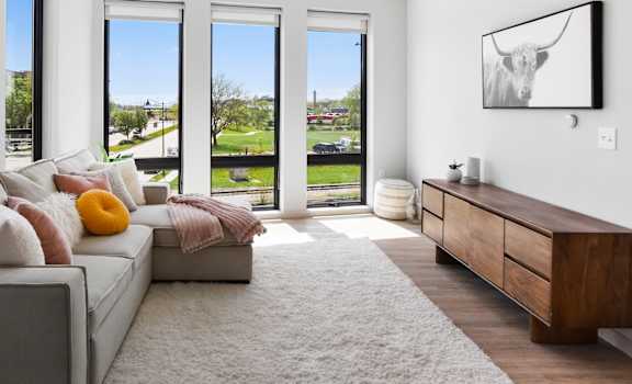 a living room with a couch and a rug and sliding glass doors