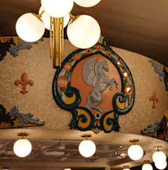 A modern bar with a green pillar and a mural on the wall at The Carousel, Richmond