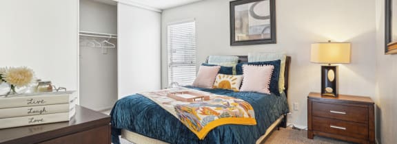 Model A2 floor plan bedroom with a bed, dresser, window Noel on The Parkway in Dallas, TX