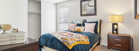 Model A2 floor plan bedroom with a bed, dresser, window Noel on The Parkway in Dallas, TX