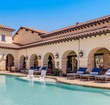 a swimming pool with lounge chairs and a hot tub in front of a building at Mission Hills Apartments, San Antonio, 78258