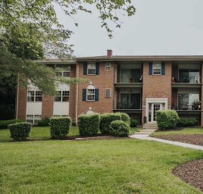 A brick building with green bushes in front.