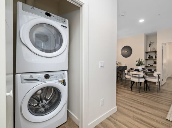 a washer and dryer in a living room next to a dining room table