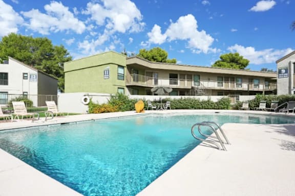 A swimming pool in front of a building with a yellow float in the water.