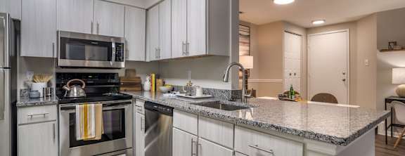 A modern kitchen with stainless steel appliances and white cabinets.