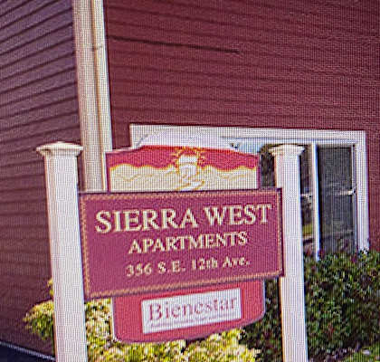 A red building with a sign that says Sierra West Apartments.