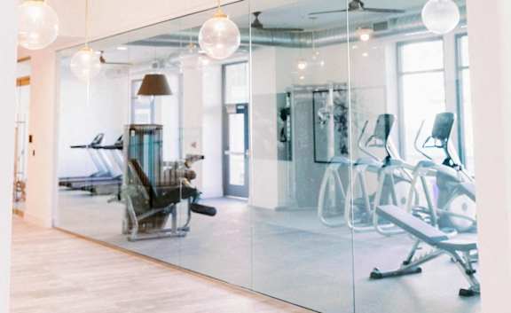 Entry to the fitness center with glass walls at The Merchant Apartments, South Carolina