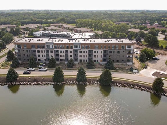 an aerial view of a building next to a lake