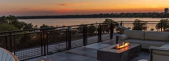 A patio with orange chairs and a view of the city.