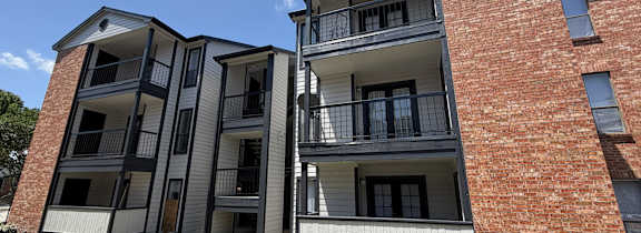 A red brick building with a white balcony.