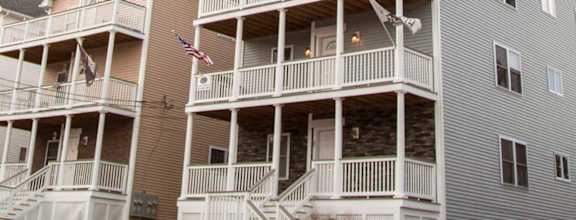 A row of multi-story apartment buildings with balconies and flags.