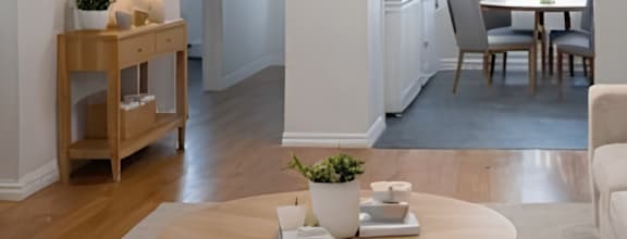 A modern dining room with a wooden table and chairs.