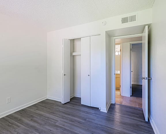 A room with a white door and a grey floor.